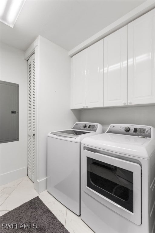 clothes washing area with separate washer and dryer, electric panel, and cabinets