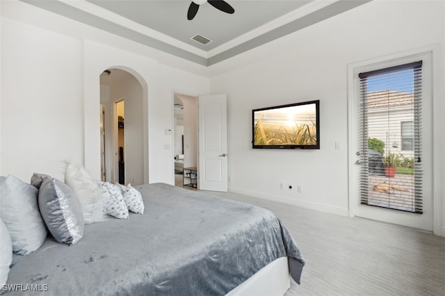 bedroom with ceiling fan, carpet flooring, and a tray ceiling