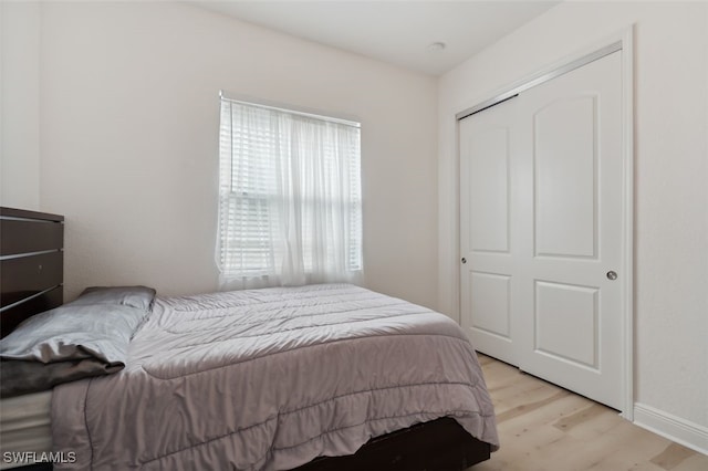 bedroom with light hardwood / wood-style flooring and a closet