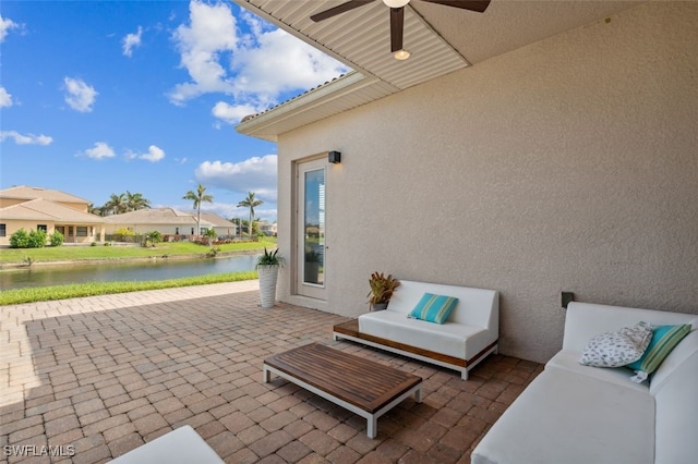 view of patio featuring a water view and ceiling fan