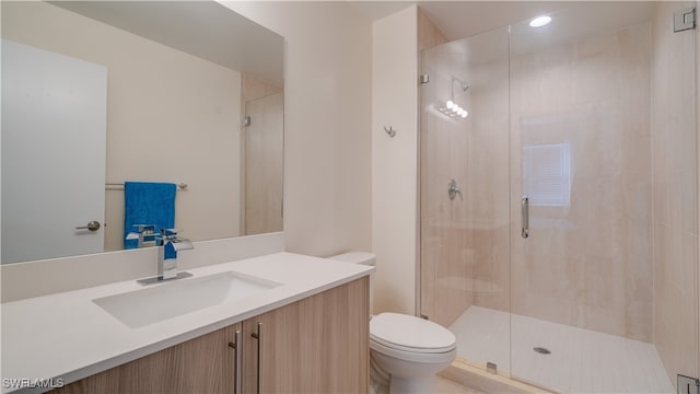 bathroom featuring vanity, toilet, and an enclosed shower