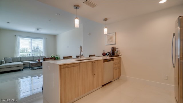 kitchen featuring kitchen peninsula, stainless steel appliances, sink, light brown cabinets, and hanging light fixtures