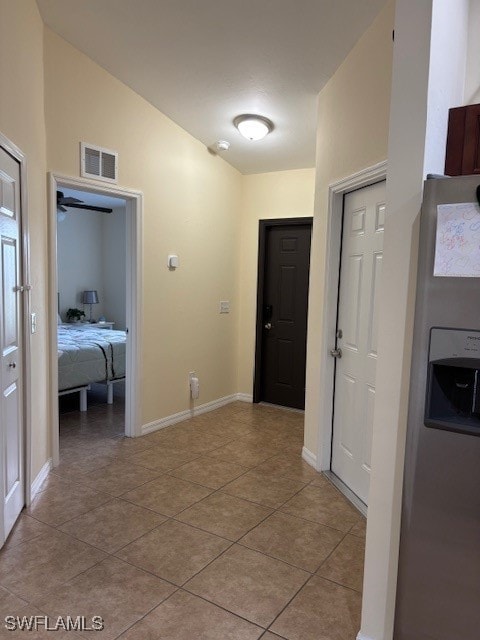 hallway with vaulted ceiling and light tile patterned flooring