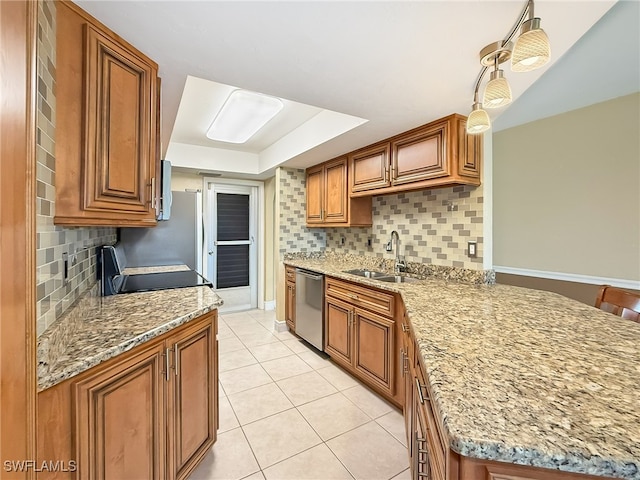 kitchen with tasteful backsplash, light stone countertops, sink, and stainless steel dishwasher