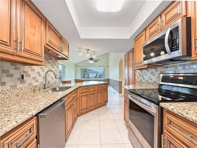 kitchen featuring appliances with stainless steel finishes, light tile patterned flooring, sink, and backsplash