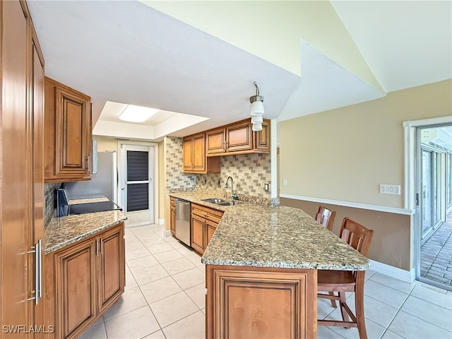 kitchen featuring dishwasher, kitchen peninsula, sink, a breakfast bar, and light stone counters