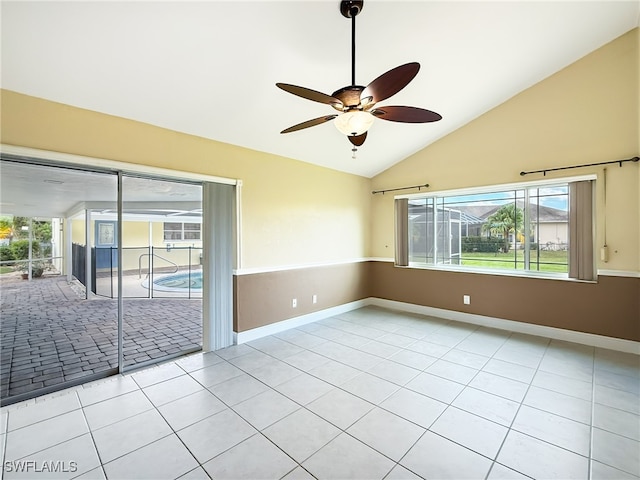 tiled empty room featuring ceiling fan, high vaulted ceiling, and a wealth of natural light