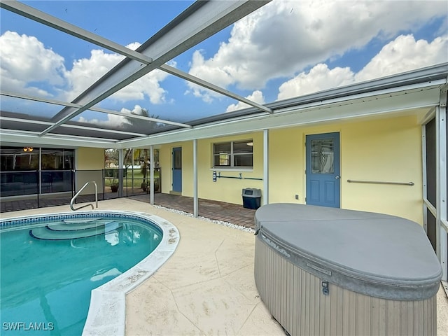 view of swimming pool featuring a hot tub, a patio, and glass enclosure