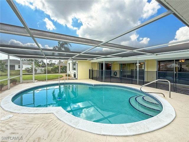 view of swimming pool with a patio area and a lanai