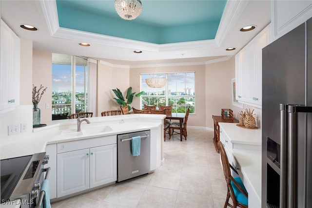 kitchen with stainless steel appliances, a tray ceiling, crown molding, sink, and white cabinets