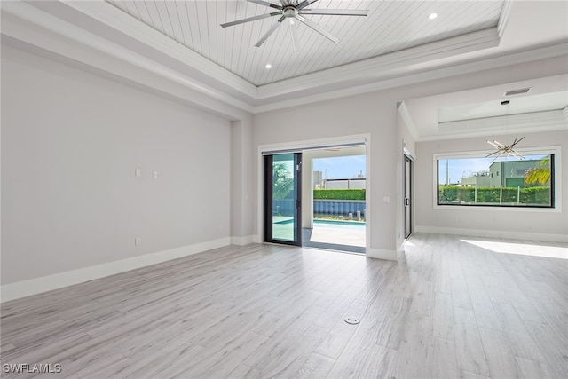 unfurnished room featuring ceiling fan, light hardwood / wood-style floors, a raised ceiling, and crown molding