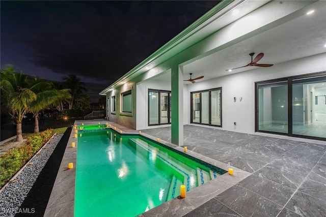 pool at twilight with ceiling fan and a patio