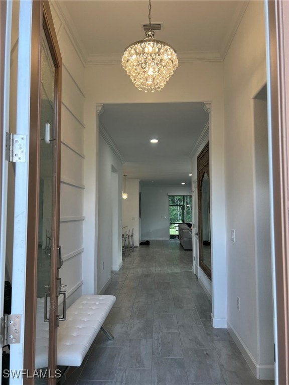 corridor with a chandelier and crown molding