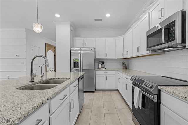 kitchen featuring sink, light stone countertops, white cabinetry, appliances with stainless steel finishes, and decorative light fixtures