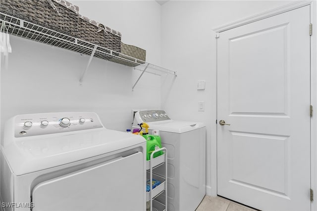 washroom with light tile patterned floors and separate washer and dryer