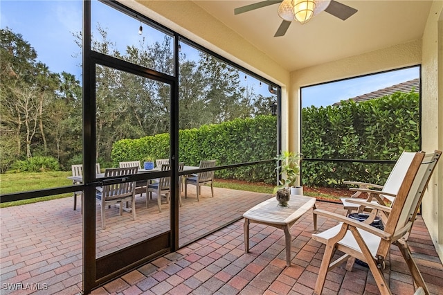 unfurnished sunroom with ceiling fan