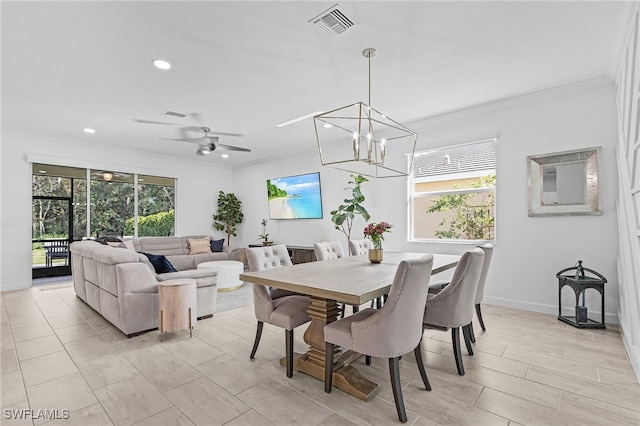 dining area featuring crown molding and ceiling fan with notable chandelier