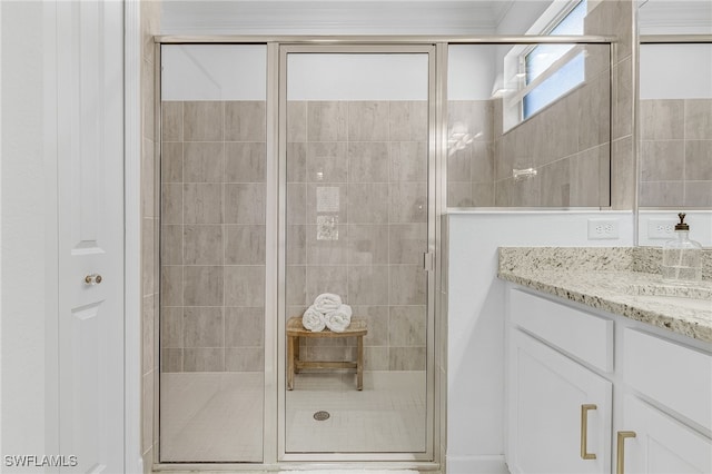 bathroom with vanity, crown molding, and a shower with shower door