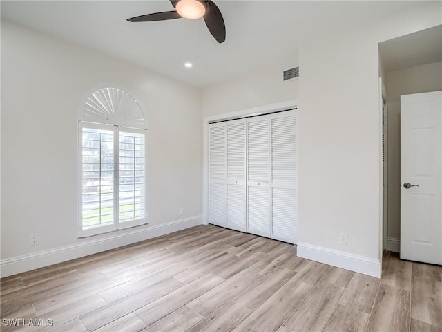 unfurnished bedroom with ceiling fan, a closet, and light wood-type flooring