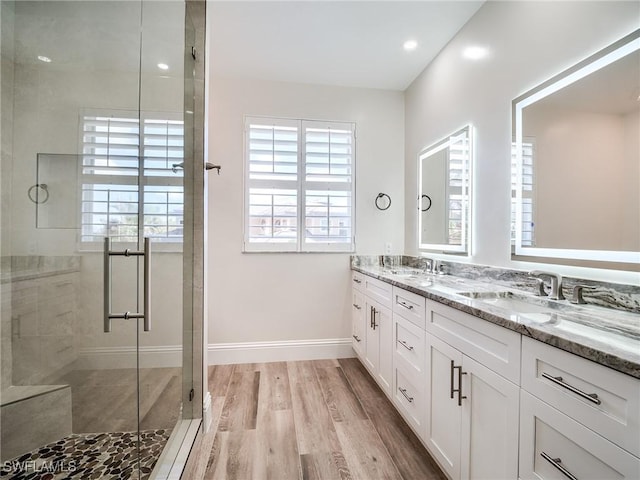 bathroom with wood-type flooring, an enclosed shower, and vanity