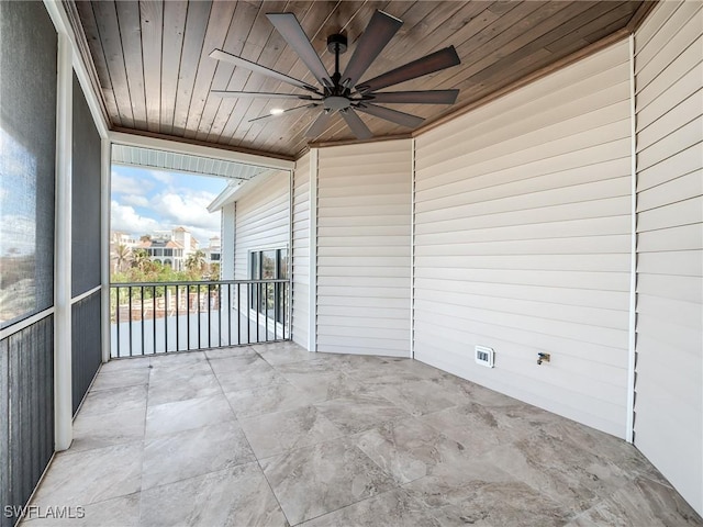 unfurnished sunroom featuring wood ceiling and ceiling fan