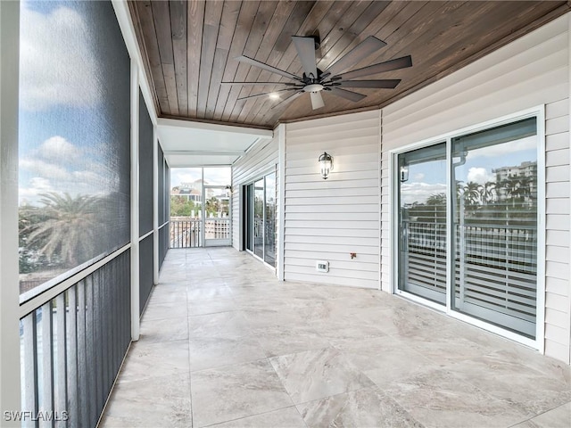 unfurnished sunroom with wood ceiling and ceiling fan