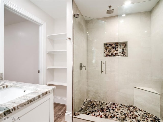 bathroom featuring vanity, a shower with shower door, and wood-type flooring