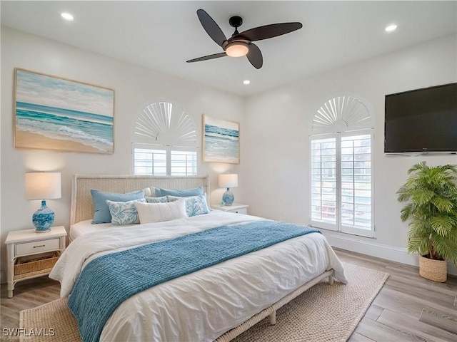 bedroom featuring multiple windows, ceiling fan, and light hardwood / wood-style floors