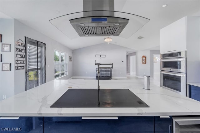 kitchen featuring white cabinetry, light stone countertops, lofted ceiling, and stainless steel double oven