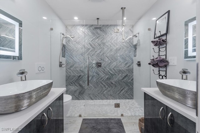 bathroom featuring vanity, toilet, and tiled shower