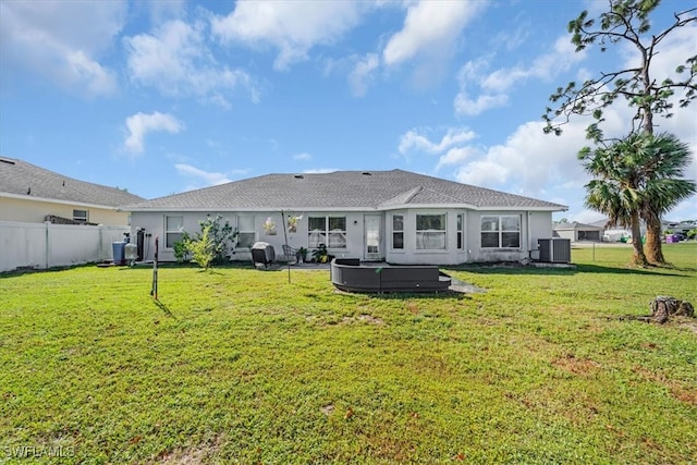 rear view of house featuring a yard, a patio, and central AC