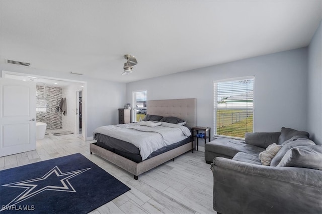 bedroom with light hardwood / wood-style floors, ensuite bath, and ceiling fan