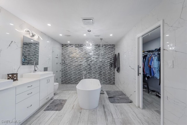 full bathroom with hardwood / wood-style floors, independent shower and bath, tile walls, toilet, and vanity