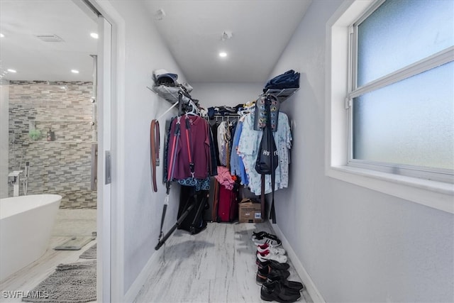 walk in closet with light wood-type flooring