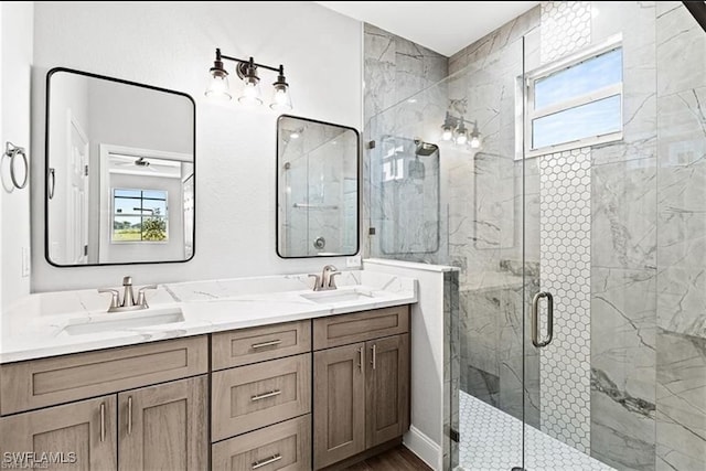 bathroom featuring vanity, a shower with shower door, and plenty of natural light