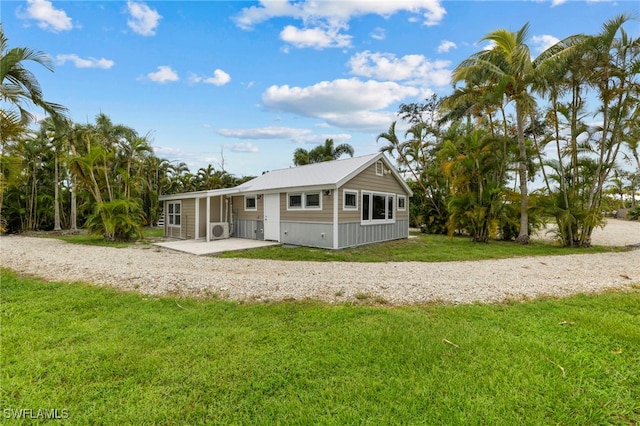 back of property featuring a lawn and a sunroom