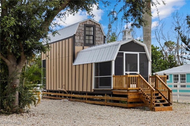 back of house featuring a sunroom and a deck