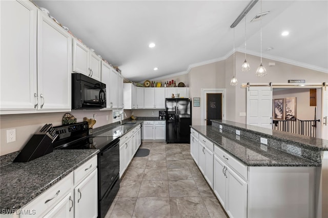 kitchen with lofted ceiling, black appliances, a barn door, crown molding, and white cabinets