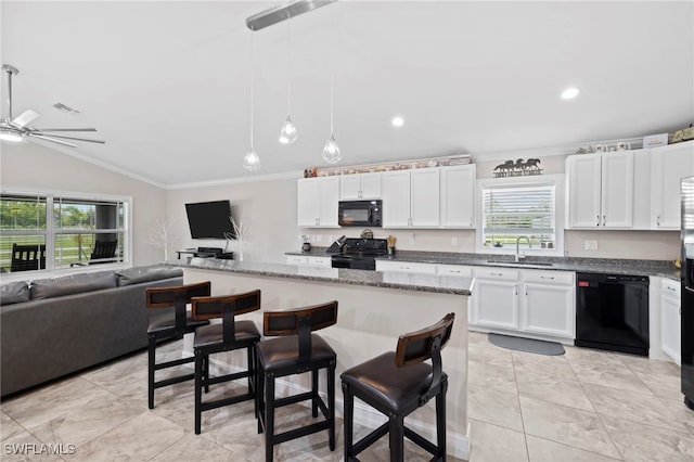 kitchen featuring white cabinets, a wealth of natural light, vaulted ceiling, black appliances, and sink