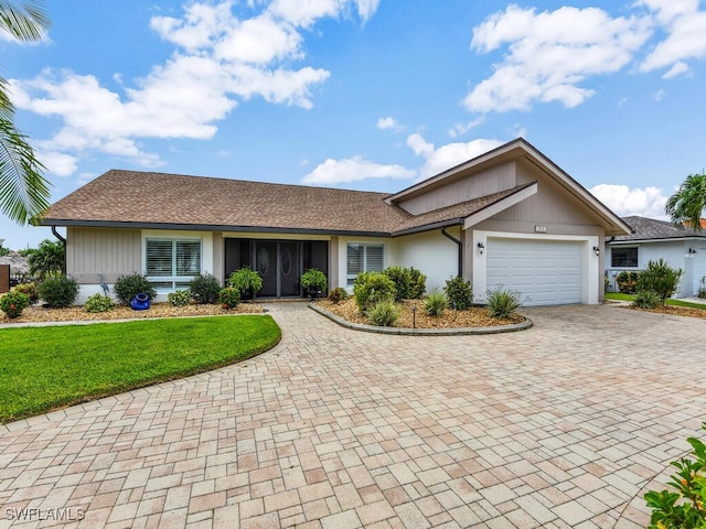 single story home with a garage and a front lawn