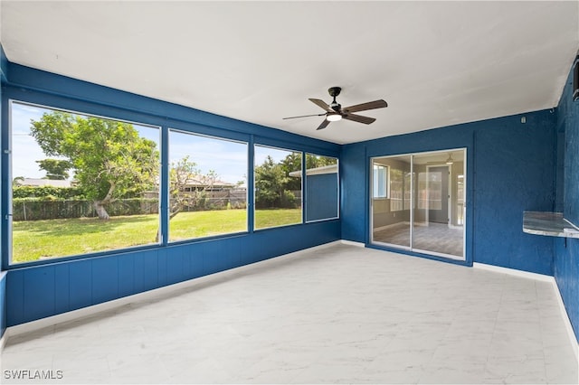 unfurnished sunroom featuring ceiling fan