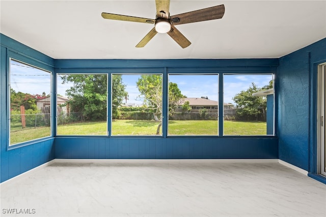 unfurnished sunroom featuring a wealth of natural light and ceiling fan