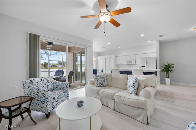 living room with ceiling fan and light hardwood / wood-style flooring