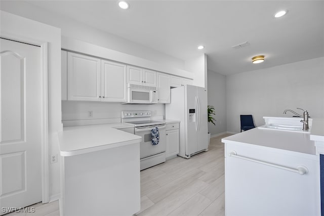 kitchen with white cabinetry, light wood-type flooring, white appliances, and sink