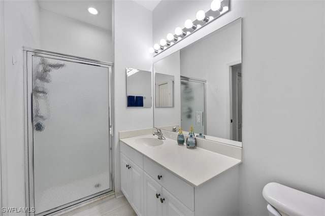 bathroom with vanity, toilet, and a shower with shower door