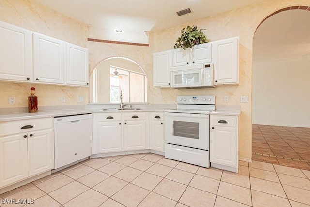 kitchen featuring white appliances, ceiling fan, sink, light tile patterned floors, and white cabinets