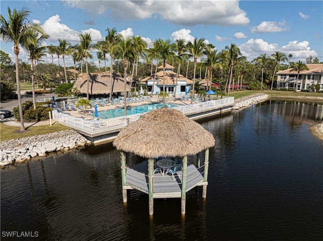 view of dock with a water view and a community pool