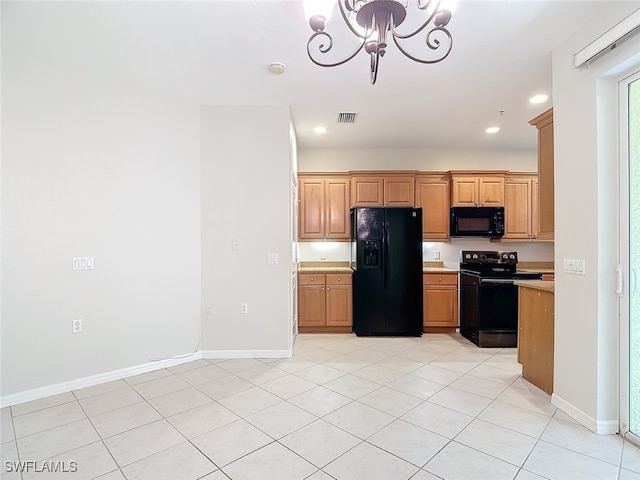 kitchen with light tile patterned flooring, a notable chandelier, and black appliances