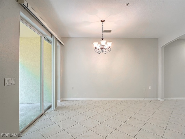 unfurnished room featuring a notable chandelier and light tile patterned floors