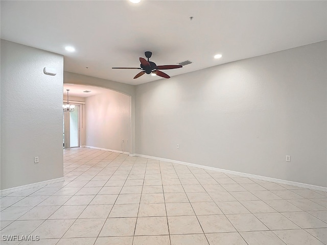 spare room with ceiling fan with notable chandelier and light tile patterned floors